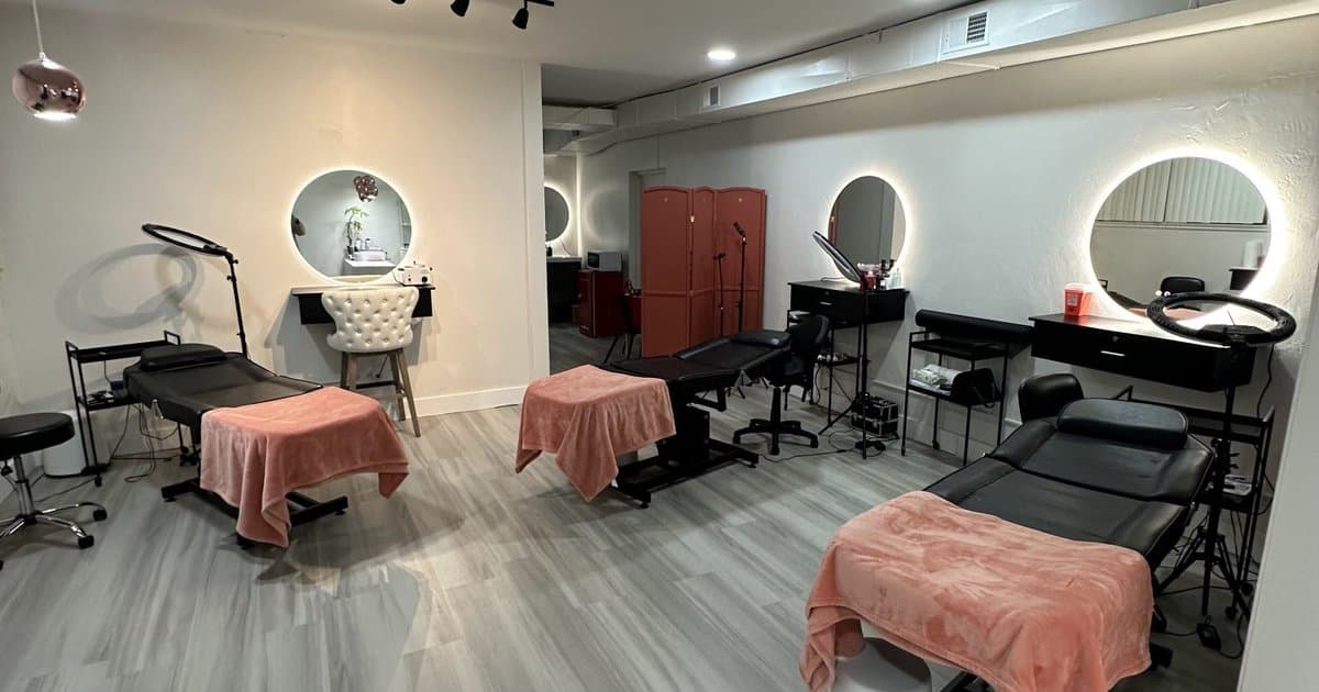 The renovated downtown hall with treatment beds, round backlit mirrors and a gray wood-look floor