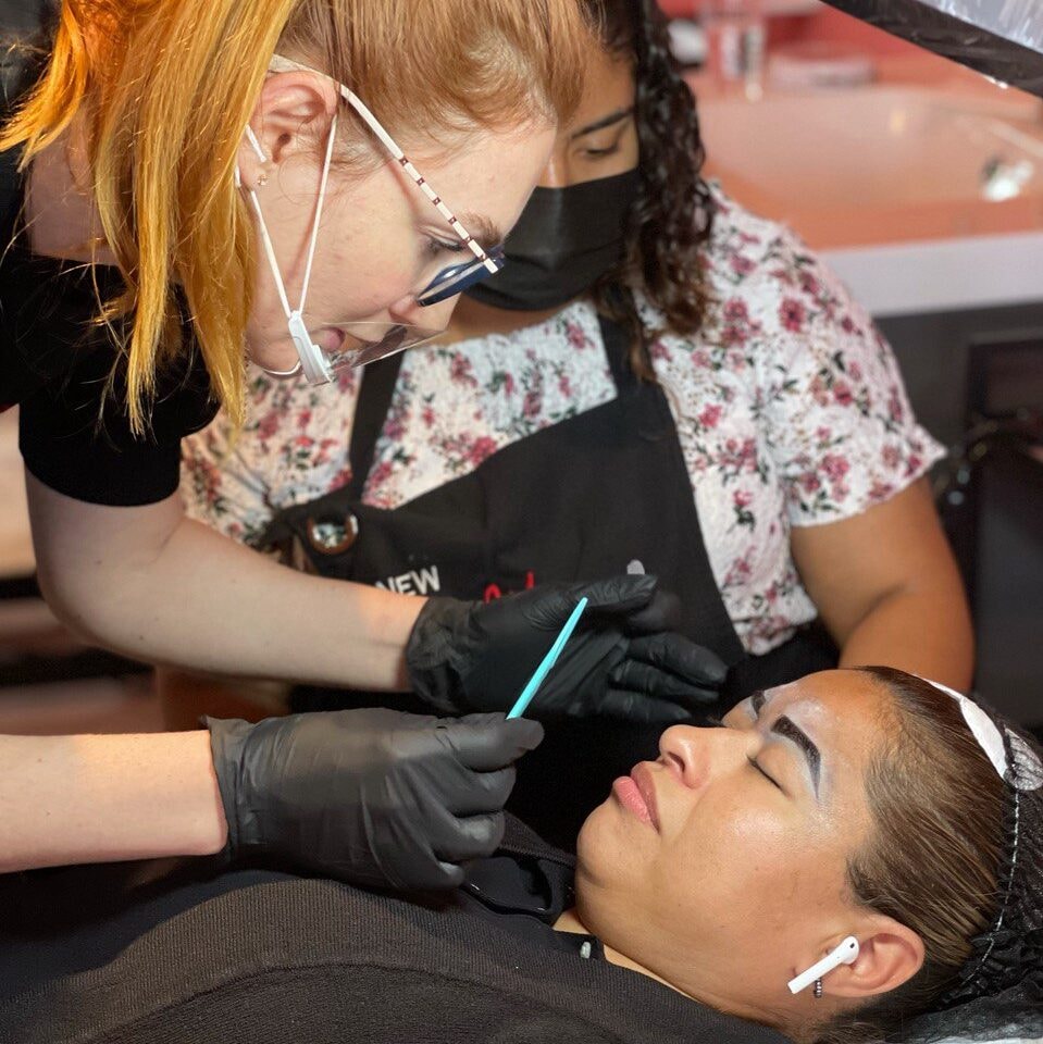 Anna Kara and a student working on brows