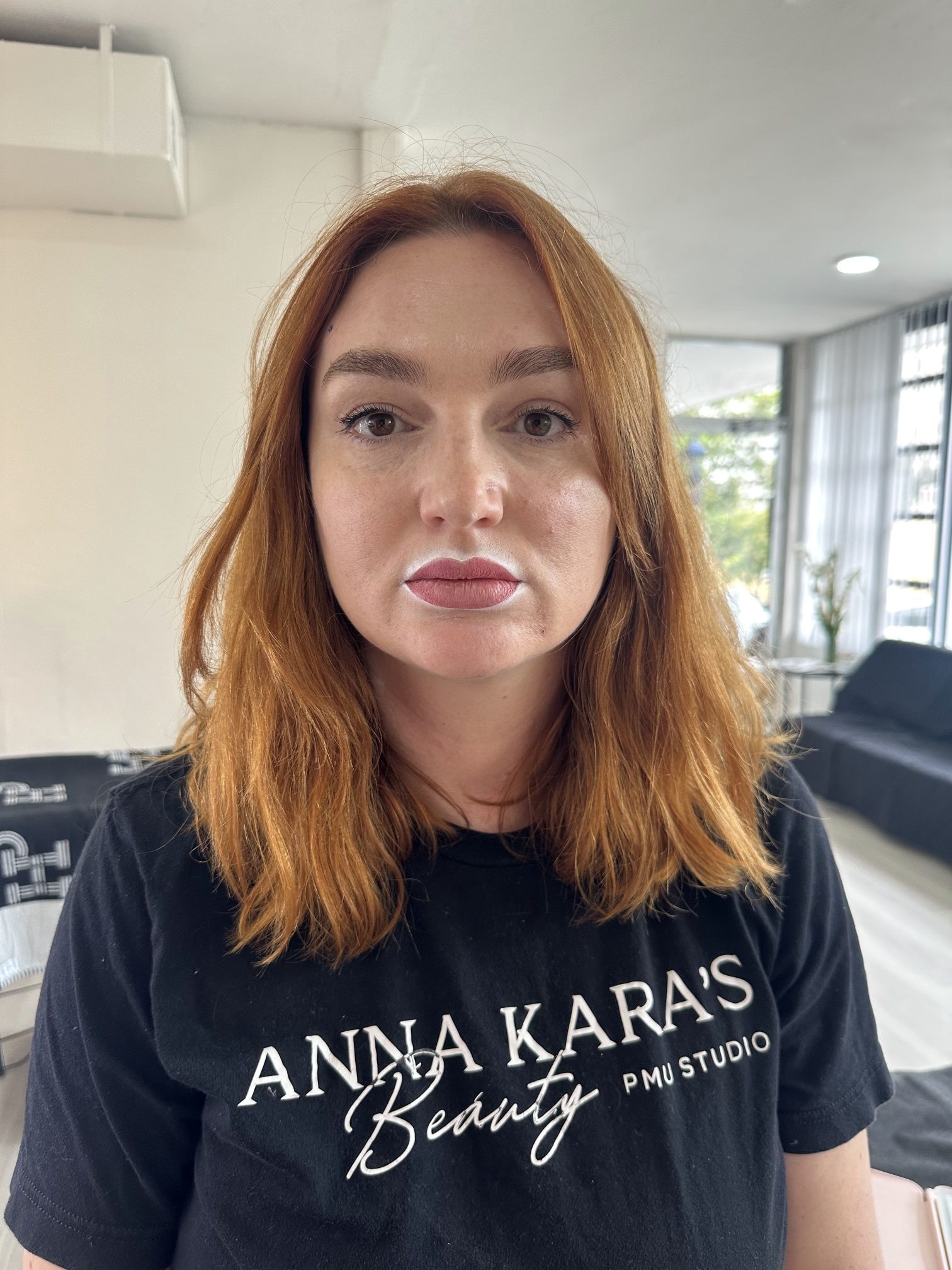 Anna Kara in a studio T-shirt, looking at the camera in the downtown studio