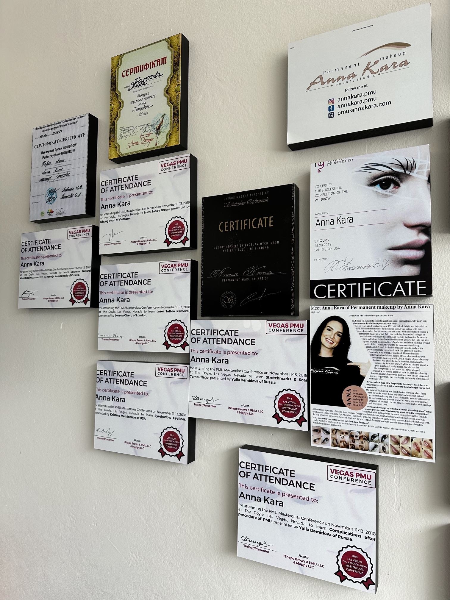 A wall of framed training certificates, including 2018 Las Vegas PMU Conference certificates of attendance for Anna Kara