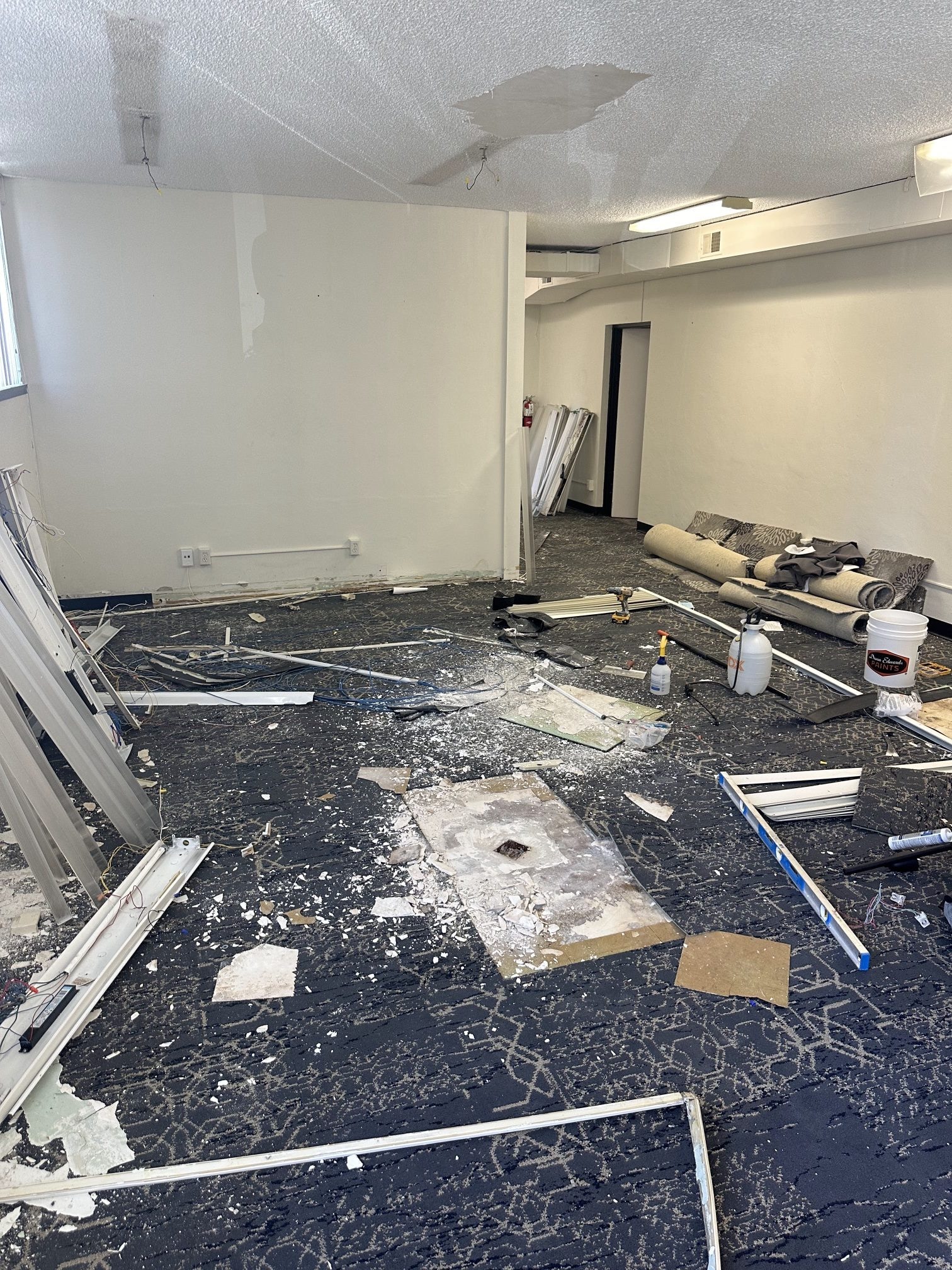 Demolition in the downtown space: torn-up carpet, ceiling fixtures and debris on the floor
