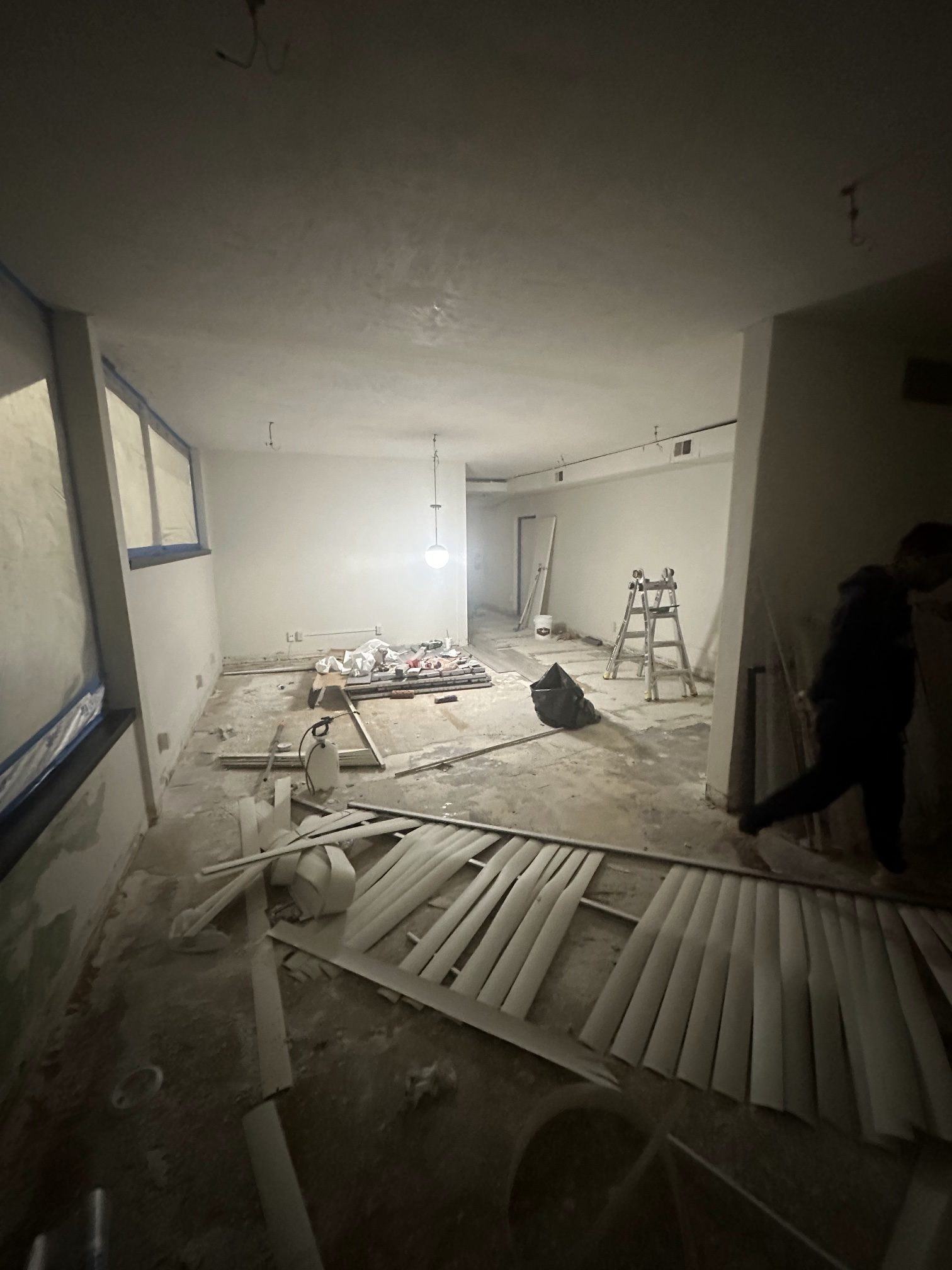 The downtown hall gutted down to the concrete floor, with taped windows and a stepladder