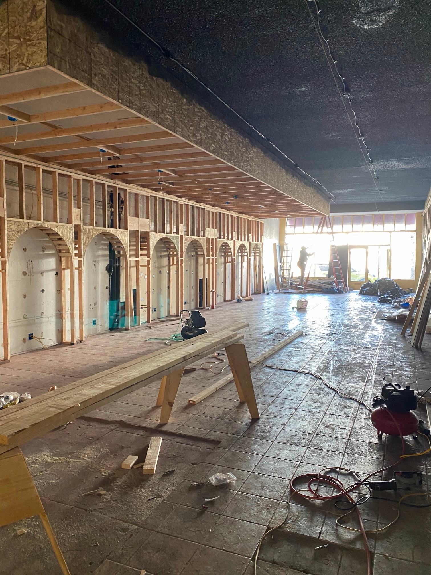 Long hall with wooden frames for arched niches along the wall during the renovation