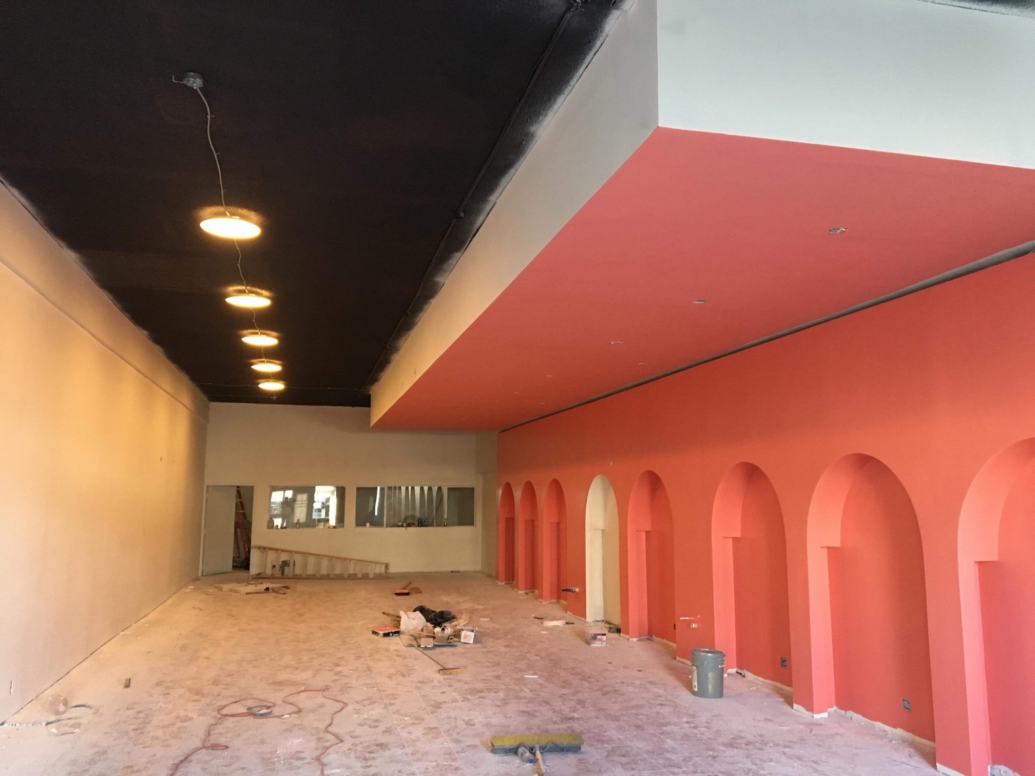 Coral painted arched niches and a dark ceiling during the renovation